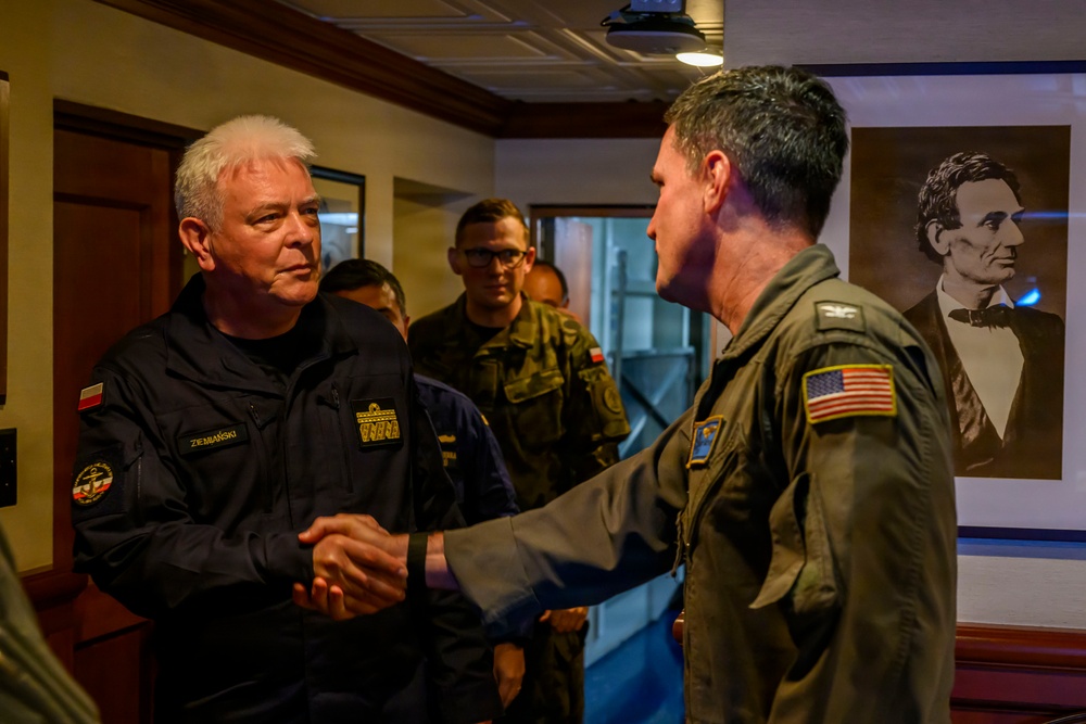 USS Theodore Roosevelt (CVN 71) Commanding Officer greets Polish Navy Rear Admiral during RIMPAC 26