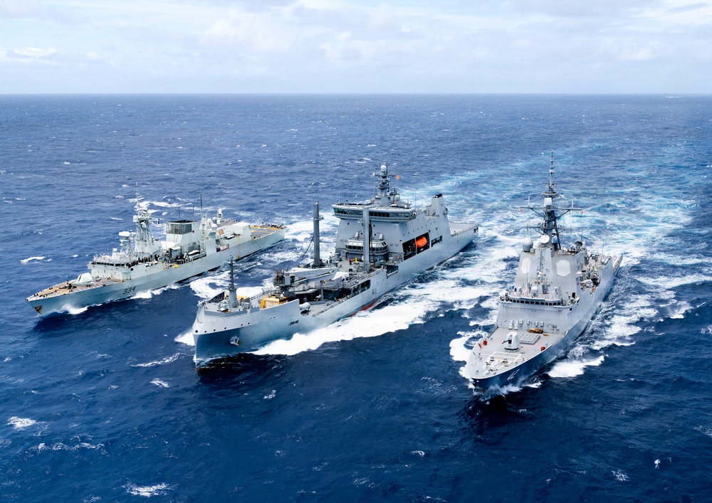 Multinational ships conduct a replenishment at sea during RIMPAC 2026