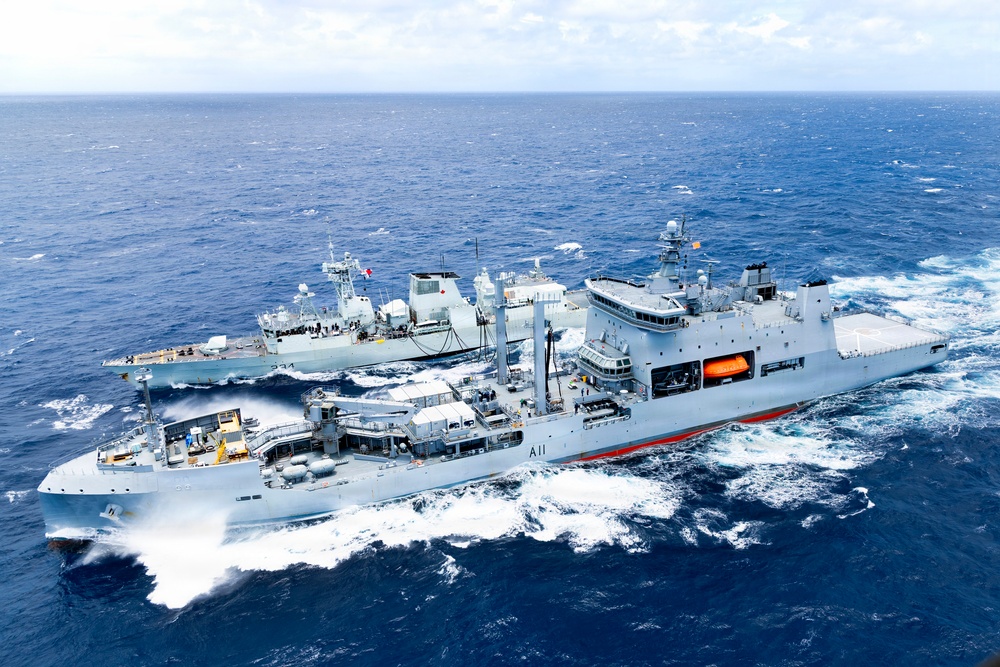 Multinational ships conduct a replenishment at sea during RIMPAC 2026