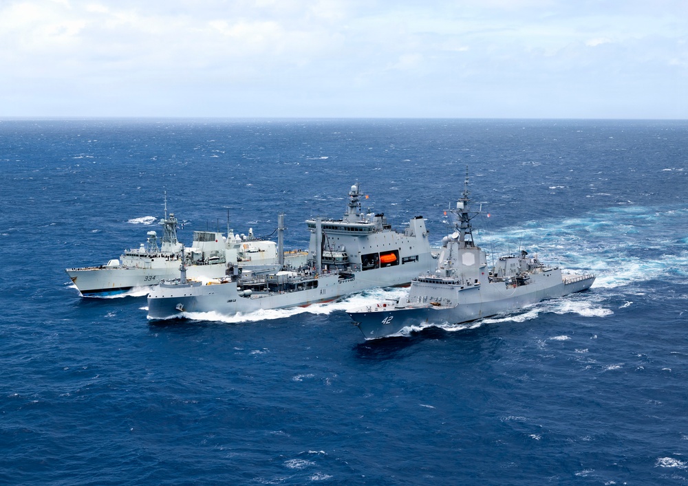 Multinational ships conduct a replenishment at sea during RIMPAC 2026