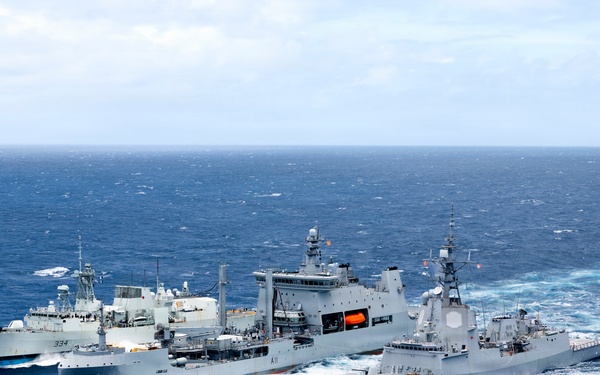 Multinational ships conduct a replenishment at sea during RIMPAC 2026