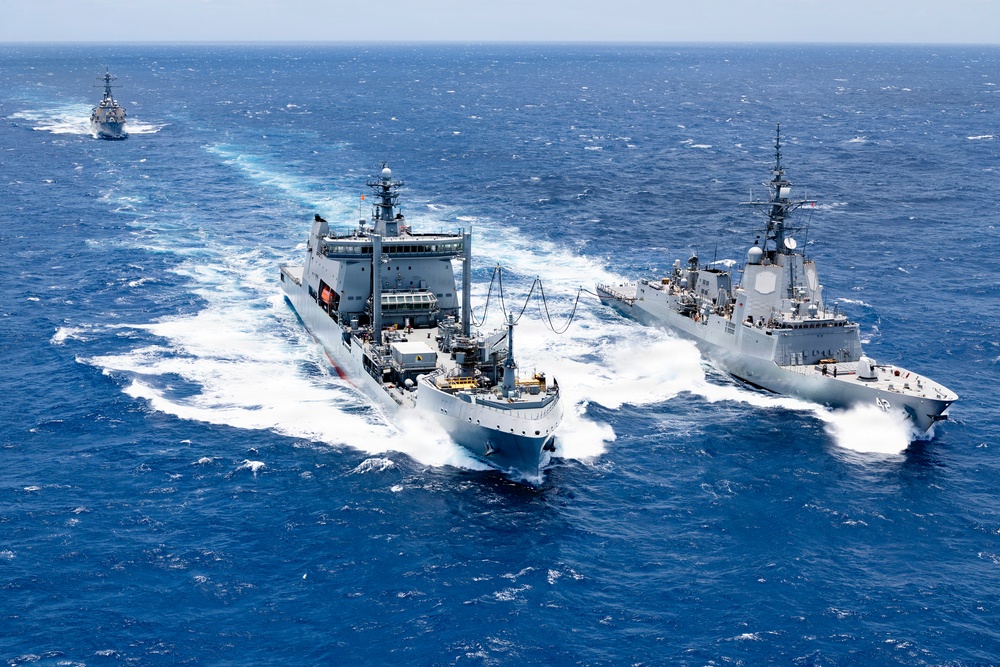 Multinational ships conduct a replenishment at sea during RIMPAC 2026