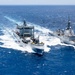 Multinational ships conduct a replenishment at sea during RIMPAC 2026