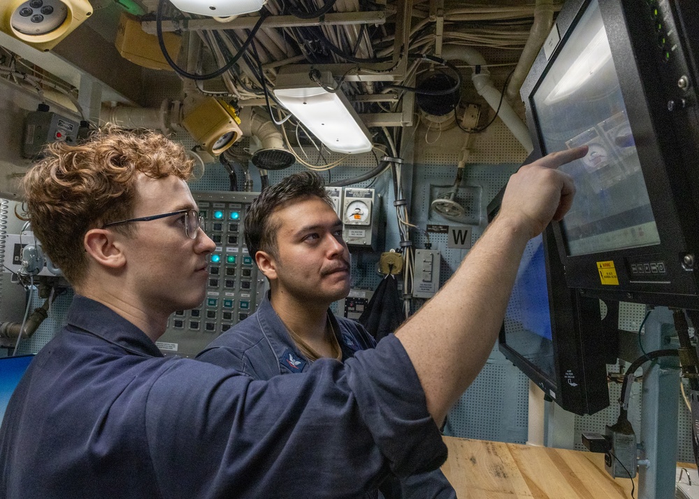 U.S. Navy Sailors Review Display Screen Aboard Naval Vessel