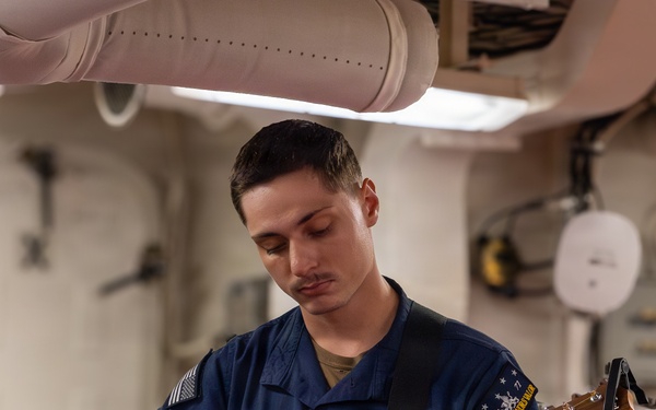U.S. Navy Sailor Plays Acoustic Guitar Aboard Warship