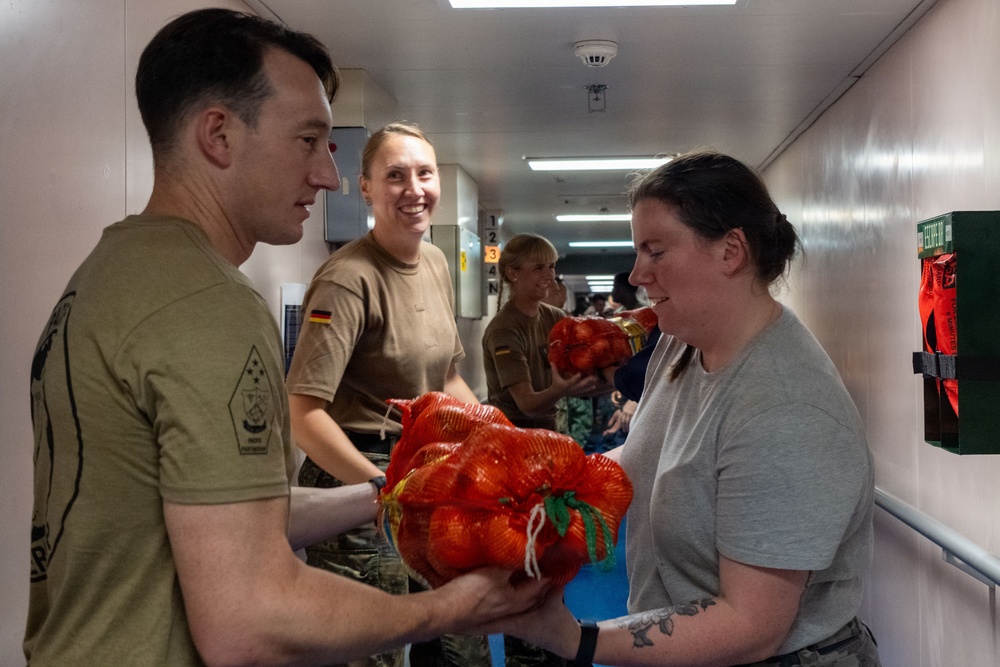 Pacific Partnership 2026 personnel embarked aboard Royal Australian Navy HMAS Choules (L100) move cargo during replenishment-at-sea