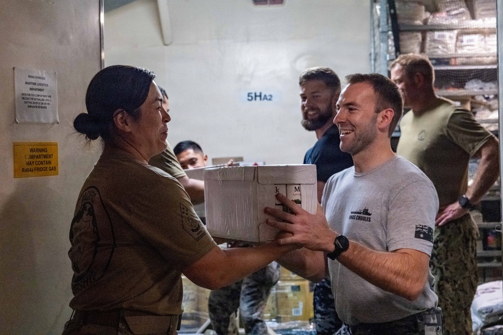 Pacific Partnership 2026 personnel embarked aboard Royal Australian Navy HMAS Choules (L100) move cargo during replenishment-at-sea