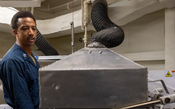 U.S. Navy Sailor Operates Laundry Equipment Aboard Naval Vessel