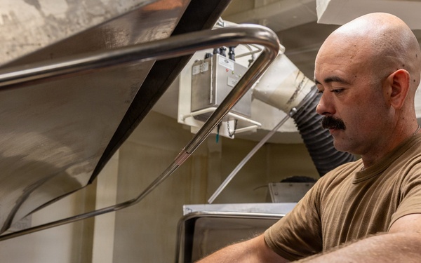 Sailor Operates Laundry Equipment Aboard Naval Vessel