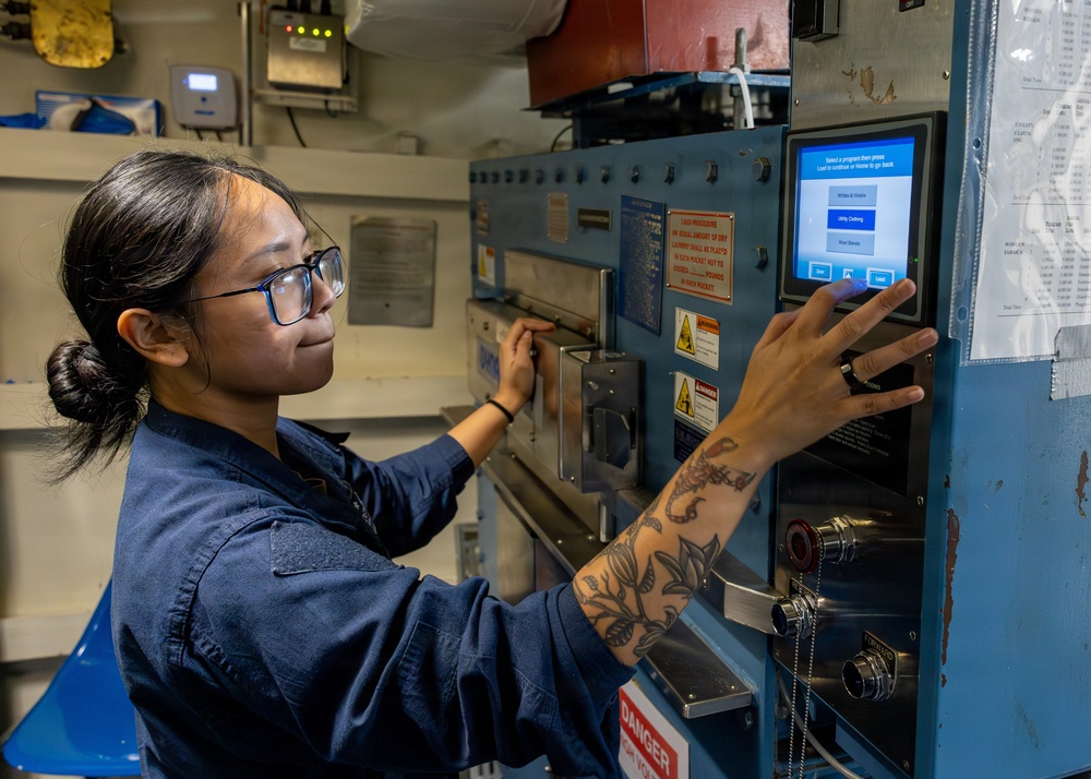 U.S. Navy Sailor Operates Industrial Laundry Equipment Aboard Naval Vessel