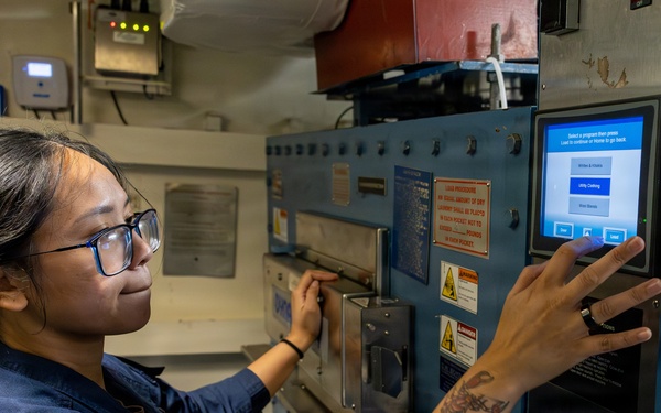 U.S. Navy Sailor Operates Industrial Laundry Equipment Aboard Naval Vessel