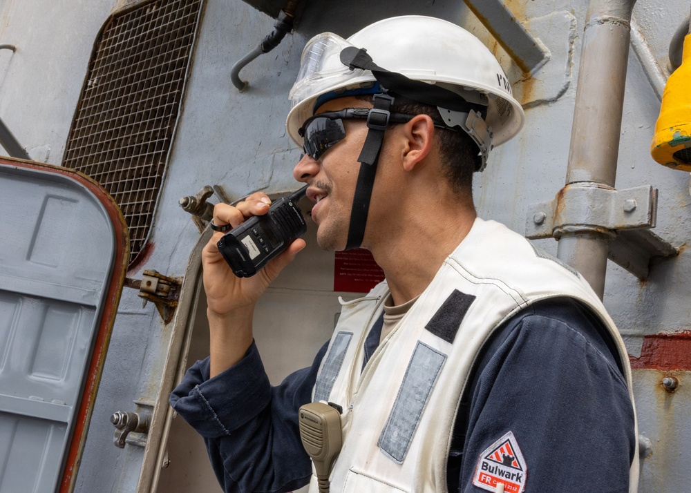 U.S. Navy Sailor Communicates via Radio Aboard Naval Vessel