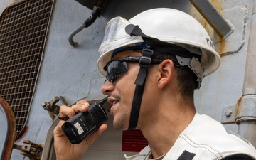 U.S. Navy Sailor Communicates via Radio Aboard Naval Vessel