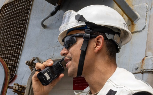 U.S. Navy Sailor Communicates via Radio Aboard Naval Vessel