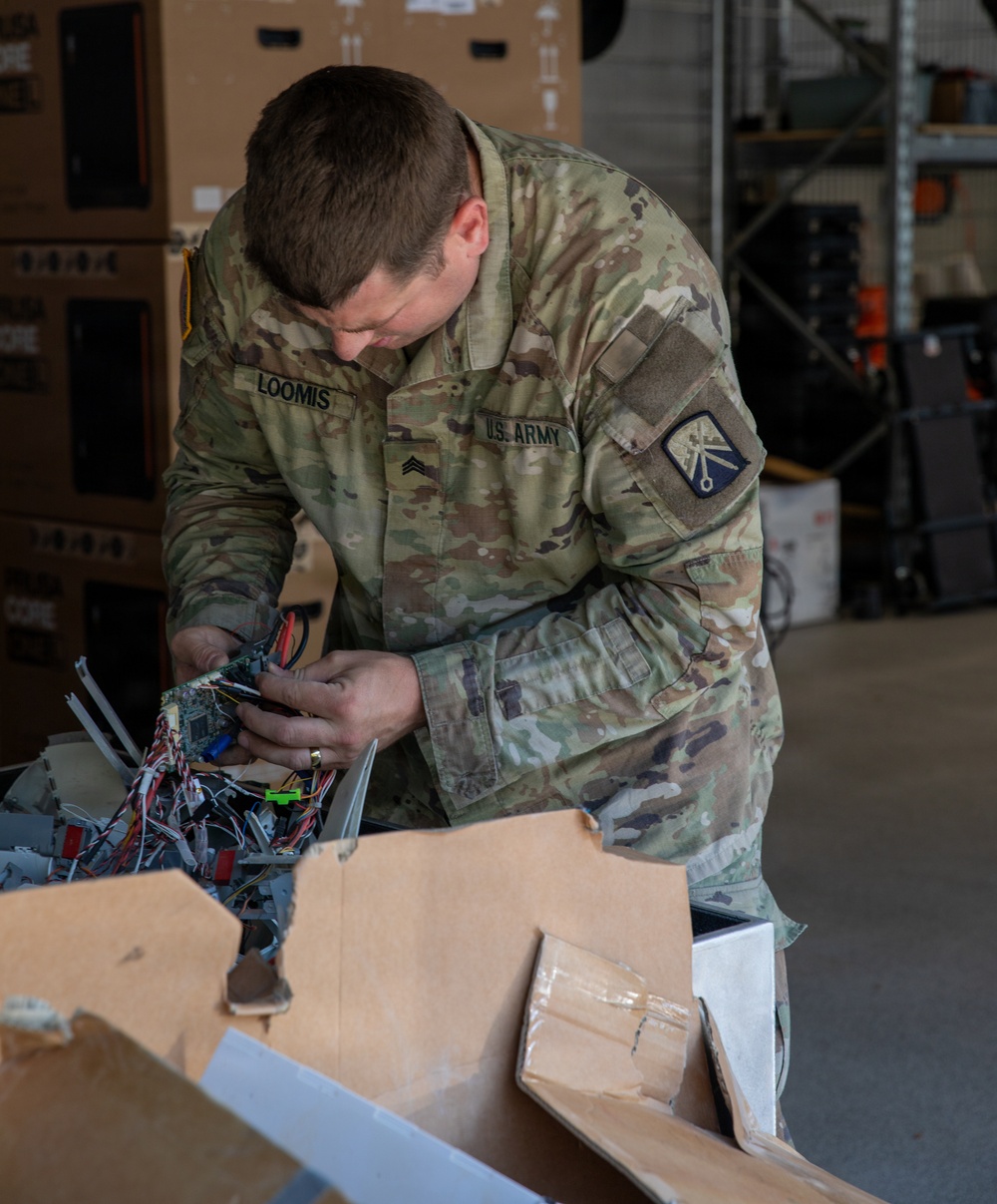 21st Theater Sustainment Command Soldier Evaluates Salvaged Drone Components
