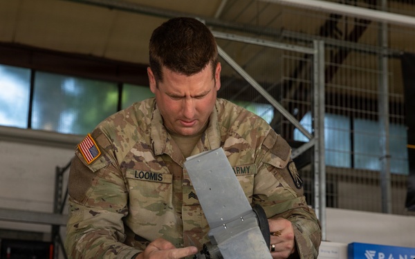 21st Theater Sustainment Command Soldier Evaluates Salvaged Drone Components
