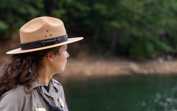 U.S. Army Corps of Engineers park ranger surveys lake shoreline during patrol operations
