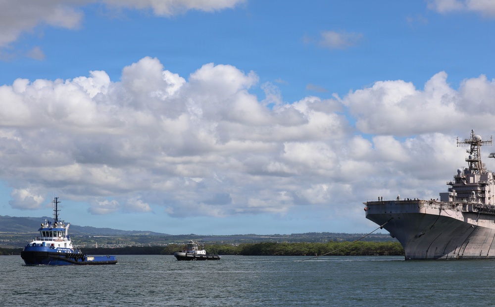 Tugboats escort hulk of decommissioned USS Peleliu during RIMPAC 26