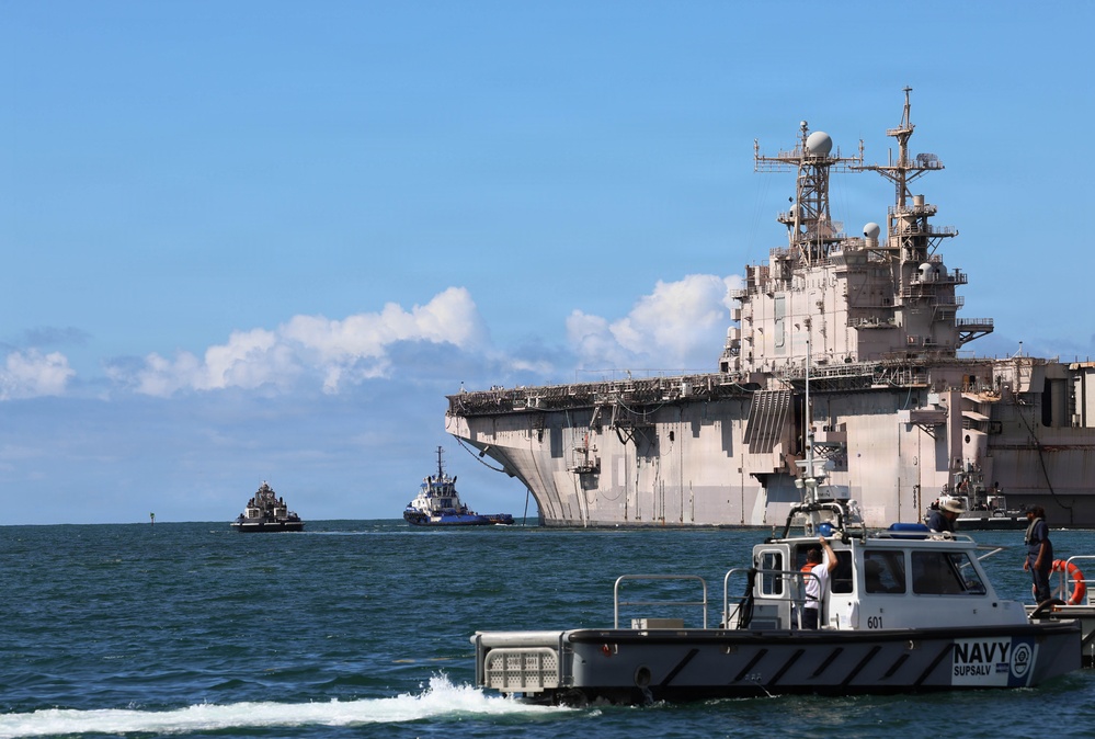 Tugboats escort hulk of decommissioned USS Peleliu during RIMPAC 26