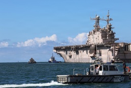 Tugboats escort hulk of decommissioned USS Peleliu during RIMPAC 26