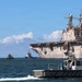 Tugboats escort hulk of decommissioned USS Peleliu during RIMPAC 26