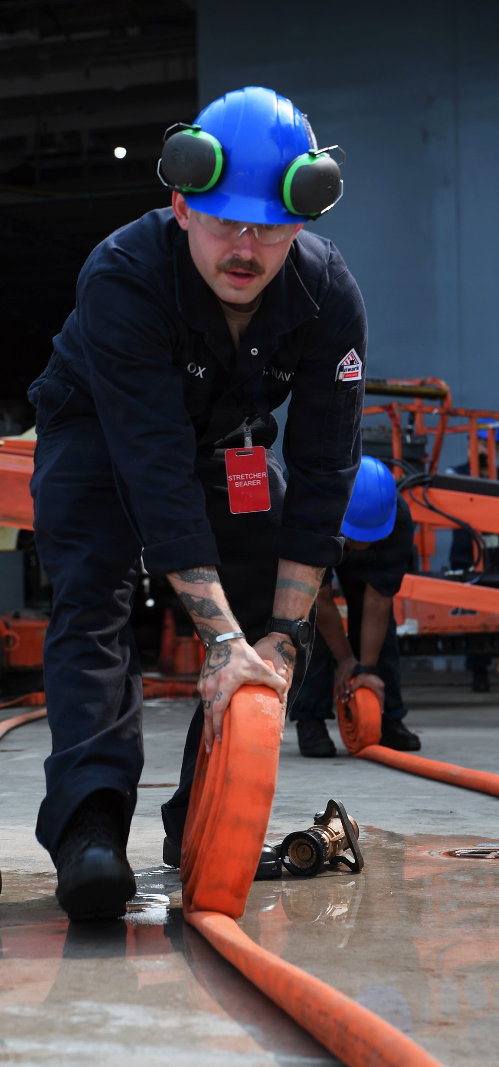 USS John C. Stennis Sailor Rolls Fire Hoses