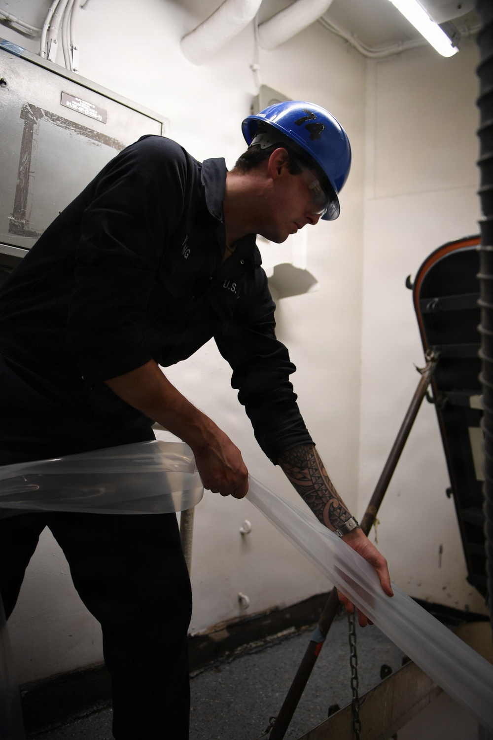 USS John C. Stennis Sailor Transports Ventilation Tubing