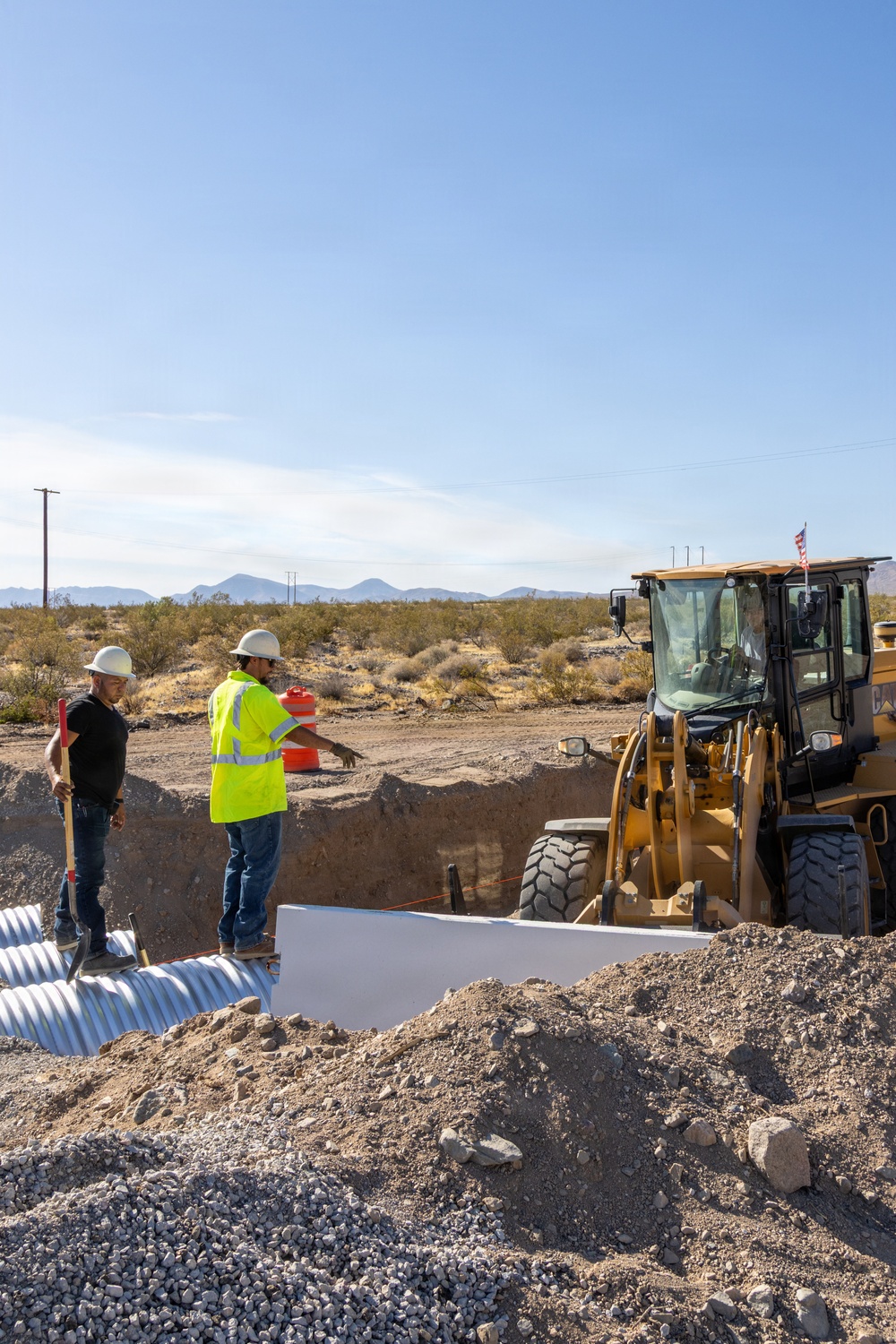 Personnel with the Base Maintenance and Engineering Department work to repair a washed-out section of Range Road aboard Marine Corps Logistics Base Barstow