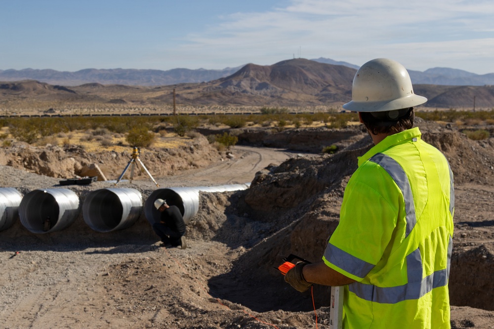 Personnel with the Base Maintenance and Engineering Department work to repair a washed-out section of Range Road aboard Marine Corps Logistics Base Barstow