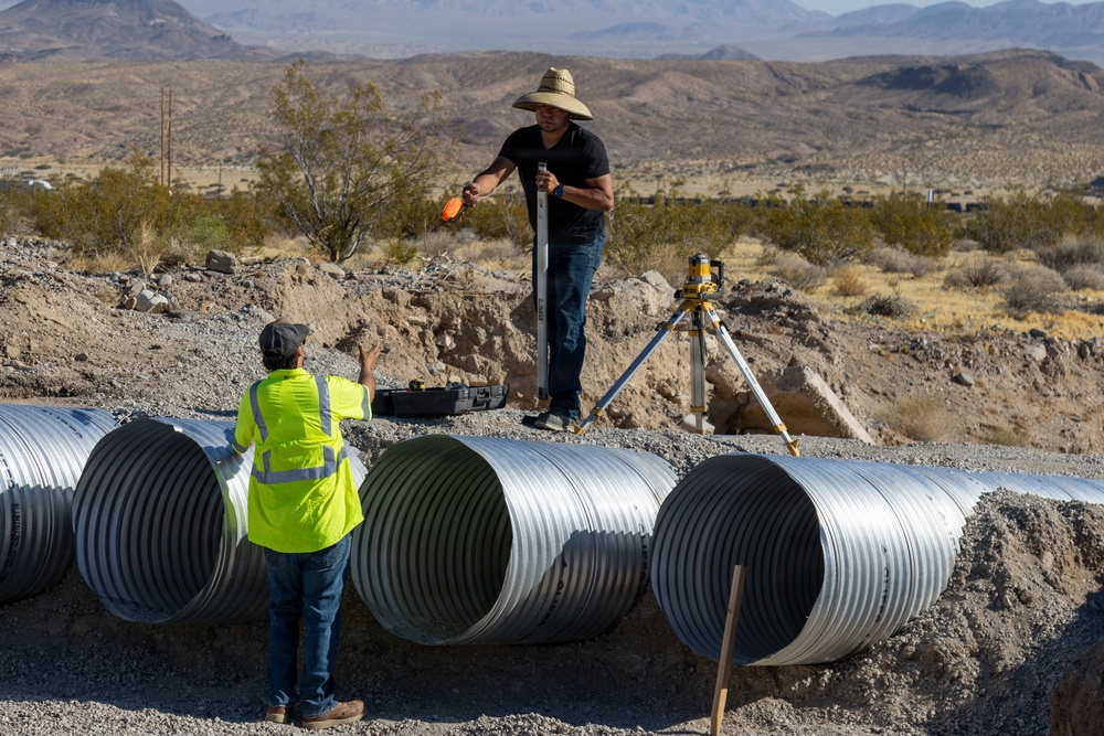 Base Maintenance and Engineering Department work to repair a washed-out section of Range Road aboard Marine Corps Logistics Base Barstow