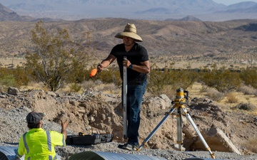 Base Maintenance and Engineering Department work to repair a washed-out section of Range Road aboard Marine Corps Logistics Base Barstow