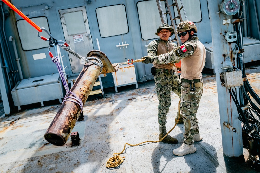 Multinational EOD technicians participate in rigging and ordnance extraction training