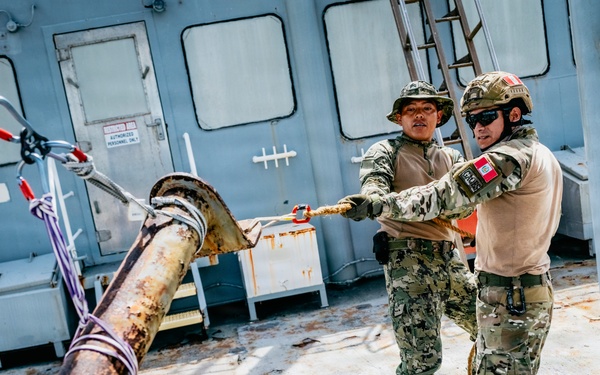 Multinational EOD technicians participate in rigging and ordnance extraction training
