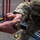 JTF-DC guardsmen prepare for patrol Two U.S. Army soldiers in MultiCam (OCP) camouflage uniforms are handling a SIG Sauer pistol magazine in an outdoor setting. One soldier appears to be passing or receiving the tan/coyote-colored magazine to/from the other. A U.S. flag patch and what appears to be a two-star general rank patch are visible on one soldier's sleeve.