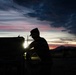 Soldier silhouetted against sunset sky during field operations