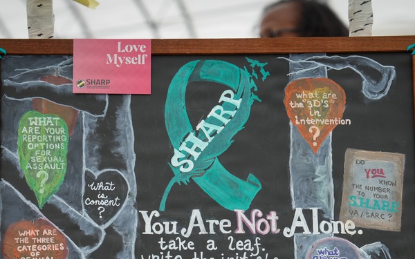 A hand-drawn chalkboard display for the U.S. Army SHARP (Sexual Harassment/Assault Response and Prevention) program, set up at what appears to be an awareness event or fair. The board features a teal awareness ribbon, motivational messaging, and interactive questions inviting participants to engage with the display. The quote 'One seed can build a resilient tree' anchors the theme of survivor support and resilience.