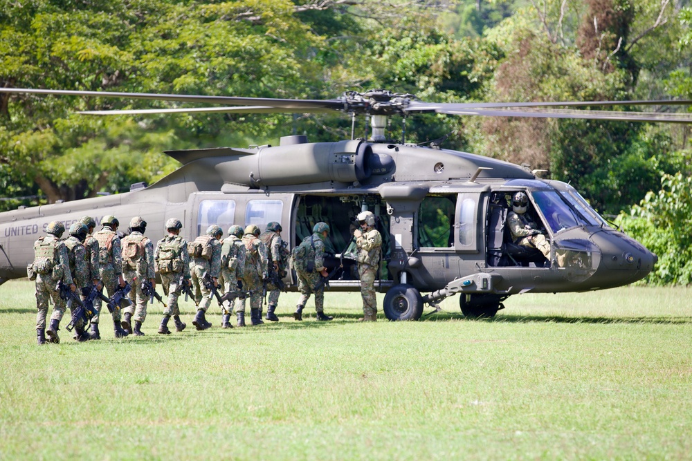 U.S. Army and Malaysian troops coordinate a simulated air-to-ground assault