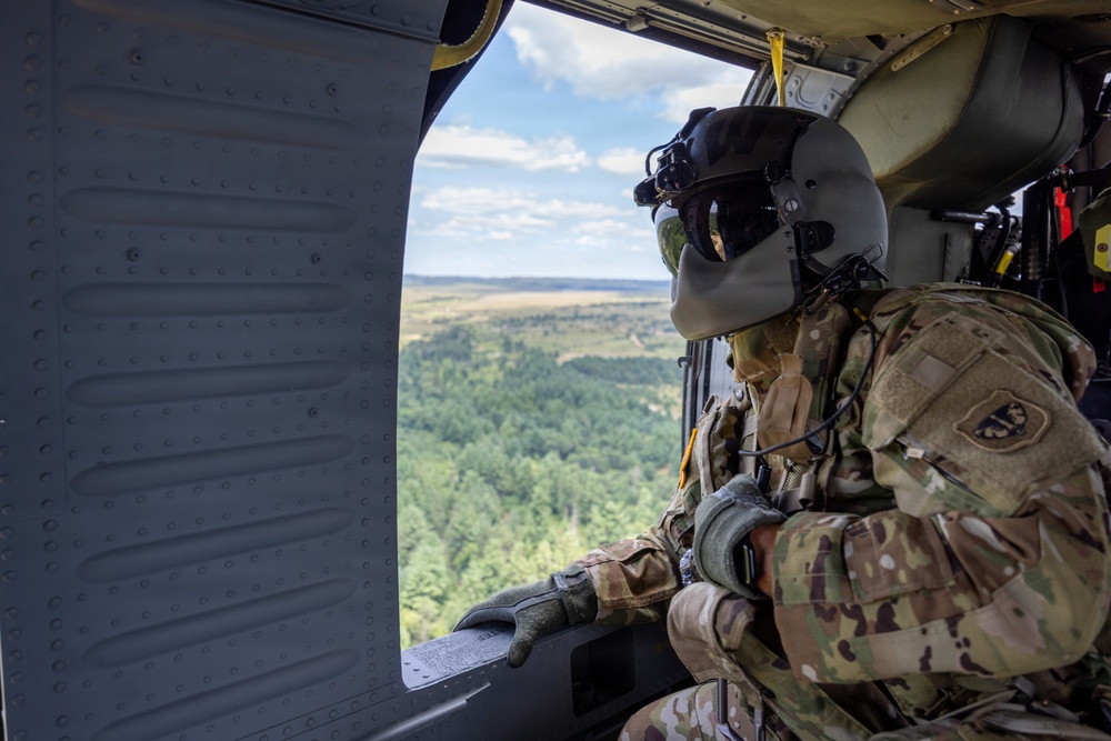 Crew Chiefr Visually Inspects Black Hawk in Flight