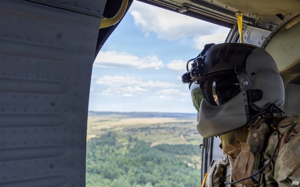 Crew Chiefr Visually Inspects Black Hawk in Flight