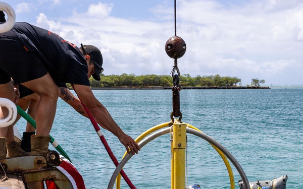 U.S. Navy Divers resurface following a salvage dive during RIMPAC 2026