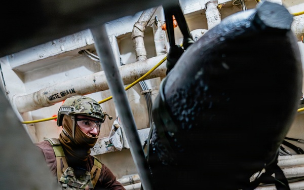 Navy Divers and EOD Technicians Conduct a Shipboard Response Drill