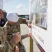Army Sustainment Command's Commander, MG Eric Shirley, and MG Christopher Schneider, Commander, PAE A&amp;A sign the future artillery complex sign for the groundbreaking ceremony at the U.S. Army Iowa Army Ammunition Plant.