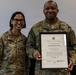 Two U.S. Army soldiers in OCP (Operational Camouflage Pattern) uniforms pose together for a photo. The soldier on the right, identified by name tape as 'BAILEY,' is holding a framed Certificate of Appointment designating him as Command Sergeant Major of the United States Army. The soldier on the left, identified as 'MALAVE,' appears to be presenting or celebrating the appointment with him.