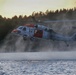 U.S. Navy MH-60S Seahawk helicopter performs low hover over water during training operations at sunset