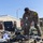 USAREUR-AF Best Squad Competition Day Zero Layout Multiple U.S. Army soldiers in OCP (Operational Camouflage Pattern) uniforms are sorting through large piles of military gear and equipment outdoors on a grassy area. The soldiers appear to be conducting a layout inspection or equipment accountability check, a common military administrative procedure. The setting appears to be a military installation or training area in a temperate region.