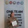 USARIEM COC/Relinquishment of Responsibility 2026 A female U.S. Army officer in Army Combat Uniform (ACU) stands before a military joint-service display wall reading 'ONE TEAM ADVANCING INNOVATIVE TECHNOLOGY & ...' She is holding a certificate and wearing a medal pinned to her uniform, suggesting she has just received a military award or commendation. Her name tape reads 'ROSSER' and she wears a Colonel's eagle rank insignia.