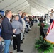 Dignitaries Stand During Remarks at Military or Civic Ceremony Held Under Large Event Tent