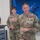 USARIEM COC/Relinquishment of Responsibility 2026 Four U.S. Army soldiers in OCP (Operational Camouflage Pattern) uniforms are gathered in what appears to be a modern military briefing or operations room. The soldier in the foreground, identified by name tape as 'MARCONI,' is wearing a red-and-white medal on his chest and appears to be speaking or addressing the group. A large digital display screen showing a tactical soldier silhouette in a blue-toned graphic is visible in the background.