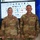 USARIEM COC/Relinquishment of Responsibility 2026 Two U.S. Army soldiers, identified by name tapes as ROSSER and MARCONI, pose together wearing dress awards (medals) on their OCP uniforms in front of a large presentation screen. The screen displays a slide titled 'Partnership' with the subtitle 'Measure, Predict, and Enhance Close Combat Performance,' featuring numerous organizational logos. A civilian woman in a blue dress is partially visible on the right side of the frame.