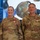 USARIEM COC/Relinquishment of Responsibility 2026 Two U.S. Army soldiers in OCP (Operational Camouflage Pattern) uniforms are posing together in front of a large digital display screen. Both soldiers are wearing red-ribboned medals, indicating a recent award ceremony. Their name tapes read 'ROSSER' (left, with Colonel eagle rank insignia) and 'MARCONI' (right, with Sergeant Major rank insignia).